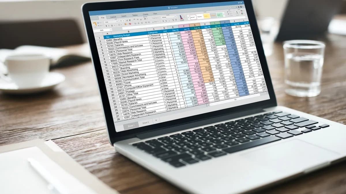 A laptop showing a spreadsheet on a desk