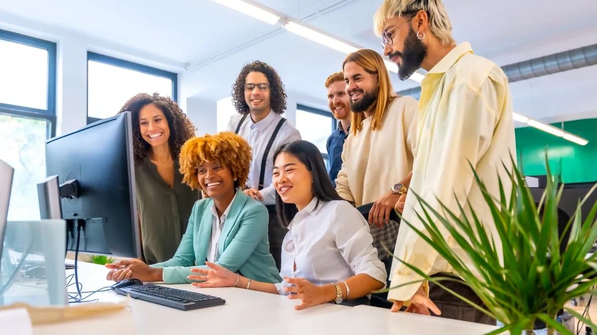 A small business team reviewing work together at a computer